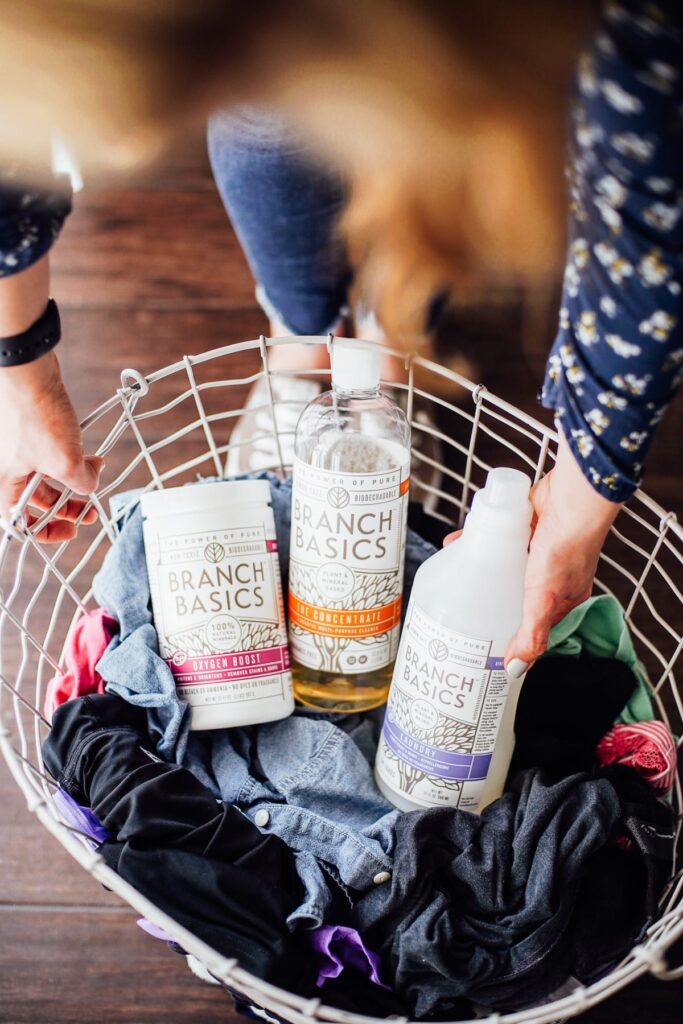 Branch Basics laundry soap and concentrate in a laundry basket. 