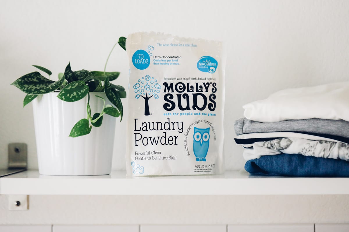 Molly Sud's bag of powder laundry soap on a shelf next to clean clothes. 