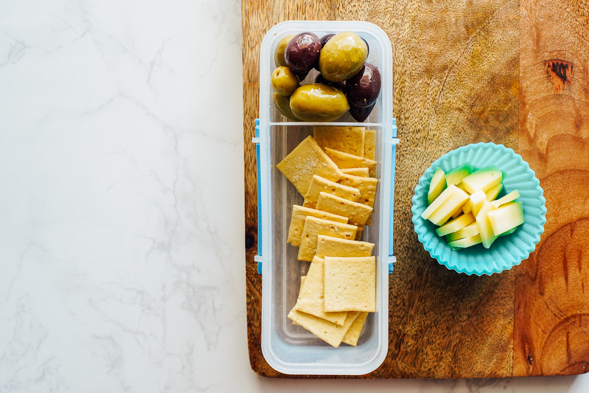 Cheese, crackers, and olives in a snack container