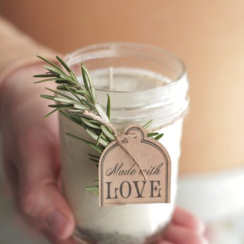 Hand holding a poured soy wax candle.