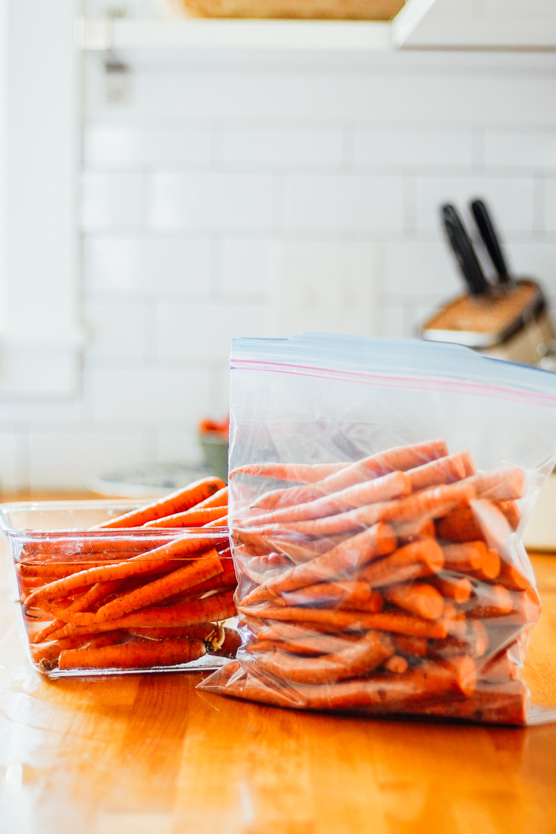 Carrots stored two ways: in a plastic bag or a container of water.