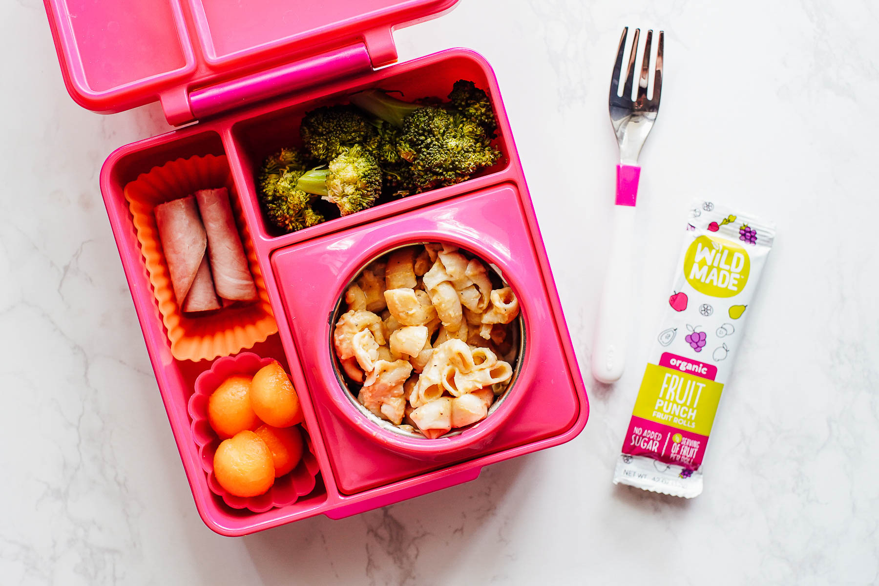 Macaroni and cheese lunch with ham rollups, roasted broccoli, cantaloup balls in a lunchbox. 